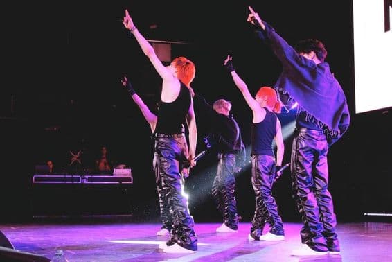 Groupe K-Pop dansant sur scène.