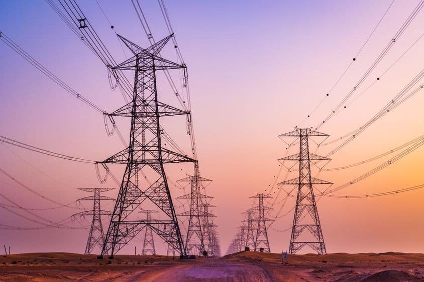 Tour haute tension avec lignes de transmission d'énergie contre un ciel coloré dans le désert d'Al Qudra, Dubaï, Émirats Arabes Unis.