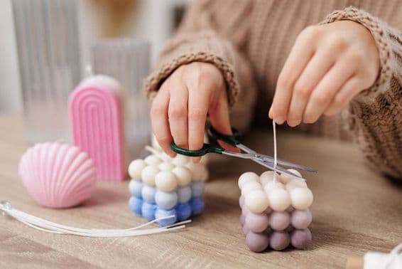 Bougie ornementale sur une table, petite fille coupe la mèche.