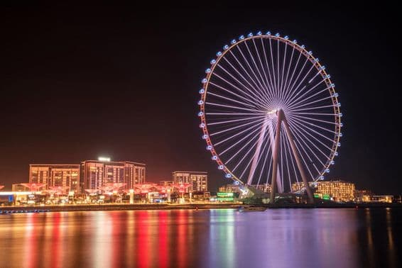 Roue Ain Dubai avec des bâtiments en arrière-plan.
