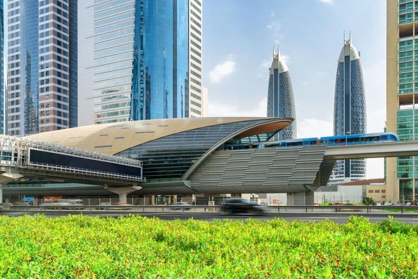 Un métro de Dubaï arrivant à la station du Centre financier au centre-ville de Dubaï, Émirats Arabes Unis, avec des gratte-ciels impressionnants en arrière-plan.