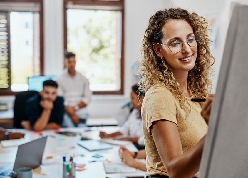 Réunion de coaching et présentation avec une designer dans un lieu de travail créatif pour le développement des compétences.