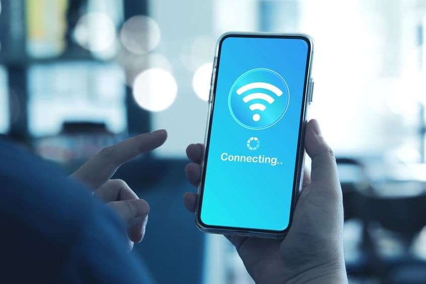 Homme utilisant un smartphone pour se connecter au Wi-Fi sur un smartphone.