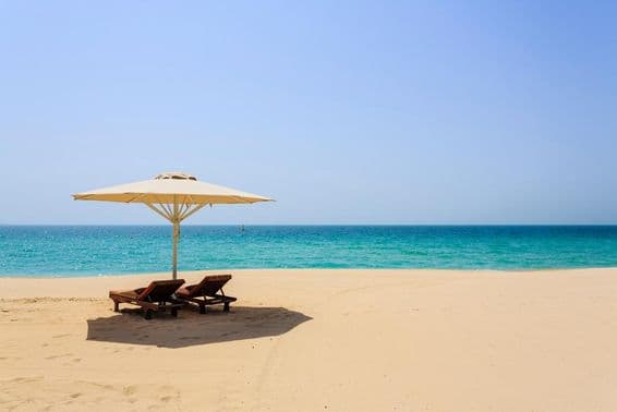Chaises longues sur la plage de sable Jumeirah, Dubaï.