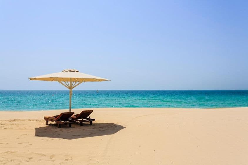 Chaises longues sur la plage de sable Jumeirah, Dubaï.
