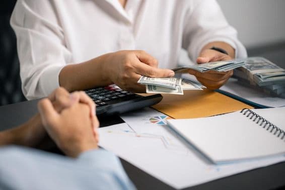 Une personne gérant sagement ses finances, épargnant de l'argent de son salaire, assurant un revenu stable pour les paiements futurs et les investissements commerciaux.