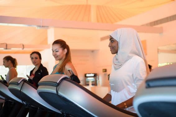 Groupe de femmes utilisant le tapis de course à la salle de sport.