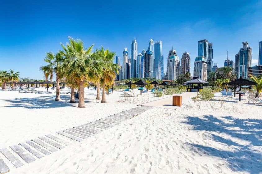 Plage de Jumeirah à Dubaï avec gratte-ciel en arrière-plan.