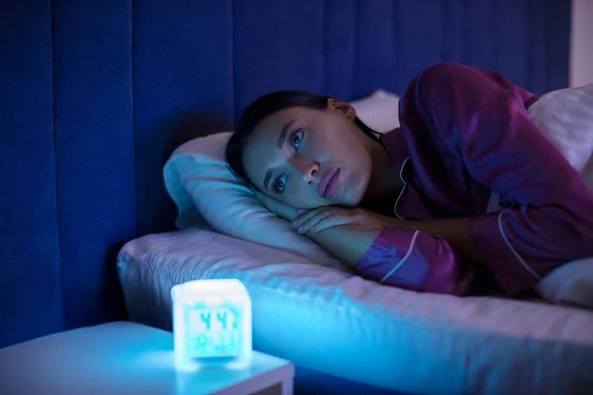 Femme insomniaque allongée au lit, regardant au loin, incapable de dormir, souffrant d'insomnie.