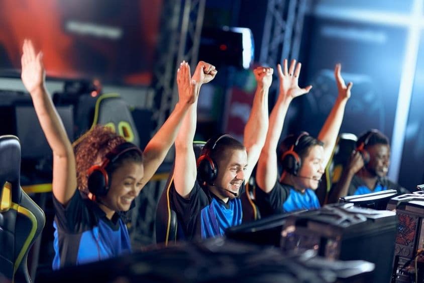 Une équipe jubilatoire de gamers célèbre un succès lors d'une compétition eSports.