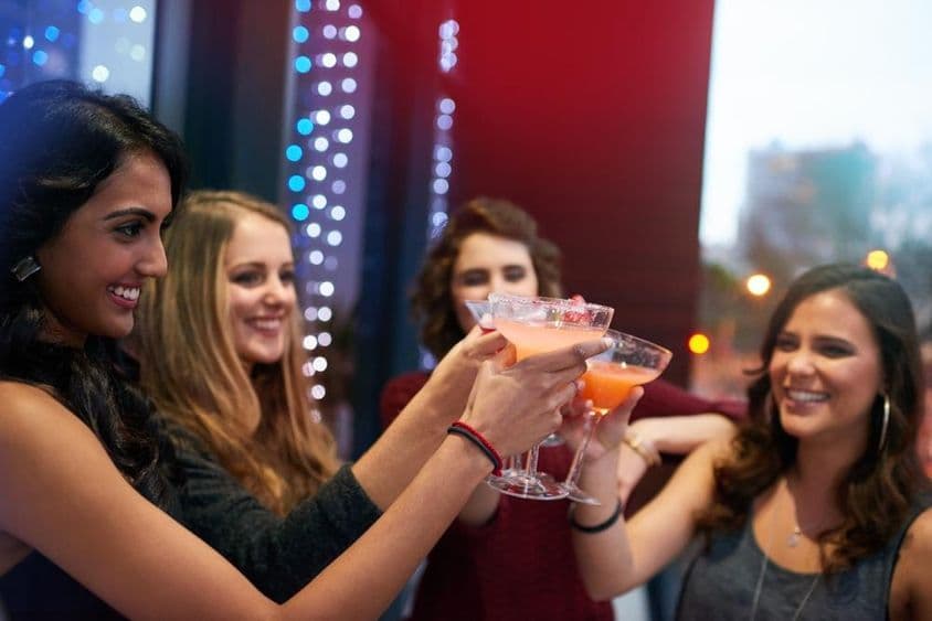 Les filles trinquent avec des boissons dans un bar à cocktails.