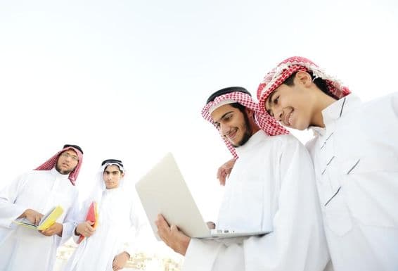 Étudiants arabes heureux regardant du contenu éducatif sur un ordinateur portable.