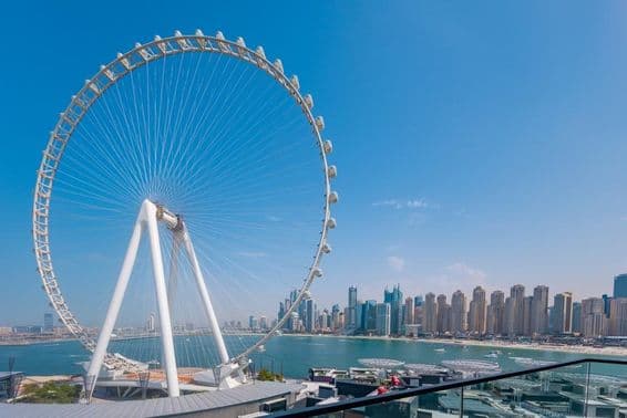 Roue Ain Dubai avec des gratte-ciel et la mer en arrière-plan.