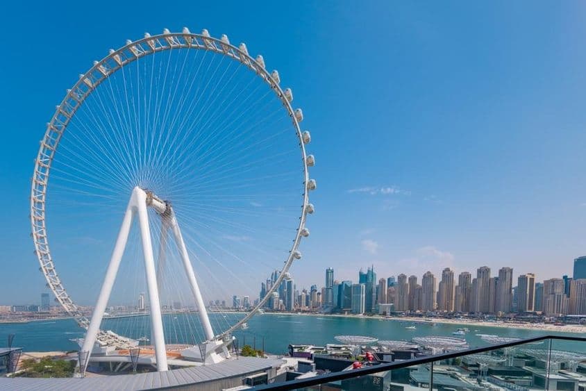 Roue Ain Dubai avec des gratte-ciel et la mer en arrière-plan.