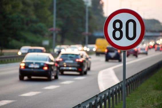 Panneau de limitation de vitesse à 80 km/h sur une route très fréquentée.