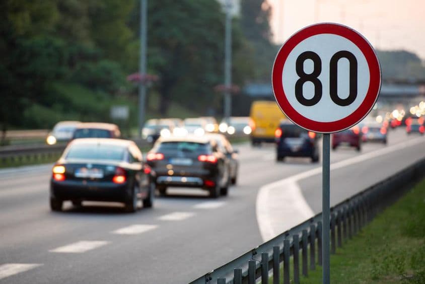 Panneau de limitation de vitesse à 80 km/h sur une route très fréquentée.