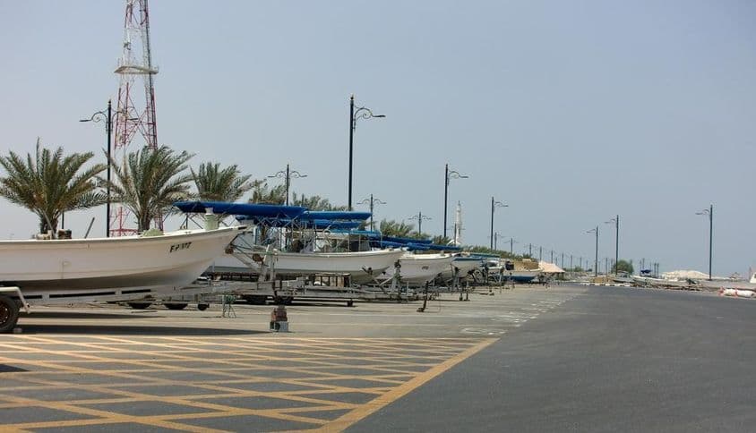 Vue de Kalba Sharjah, ÉAU avec des bateaux de pêche alignés le long de la côte.