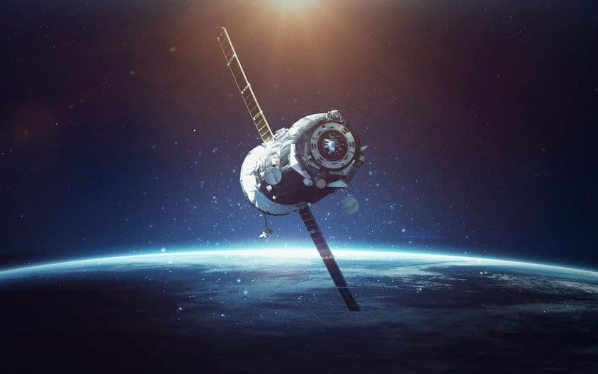 Satellite avec planète bleue en arrière-plan.