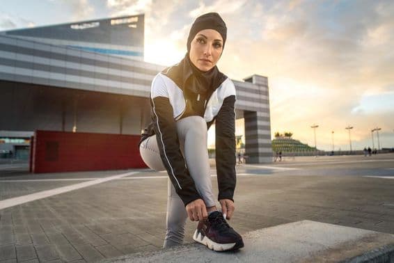 Femme musulmane faisant de l'exercice de course en ville au centre-ville.