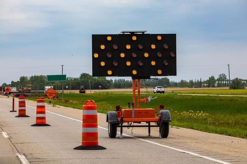 Lumières orange clignotantes avec flèches et cônes de signalisation guidant les conducteurs pendant les fermetures de voie.