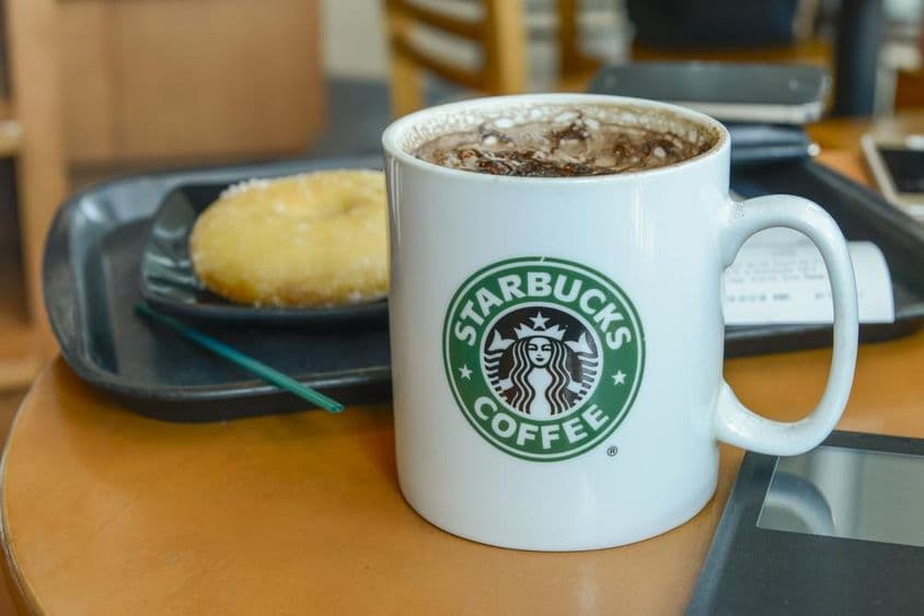 Cappuccino au cacao dans un mug chaud et fumant dans un café Starbucks.