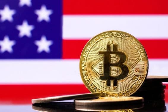 Pièce en métal Bitcoin dorée avec le drapeau des États-Unis en arrière-plan.
