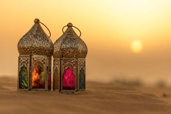 Lanterne arabe dans un désert au coucher du soleil.
