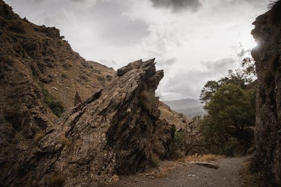 Roc saillant sur un chemin de montagne par jour nuageux.