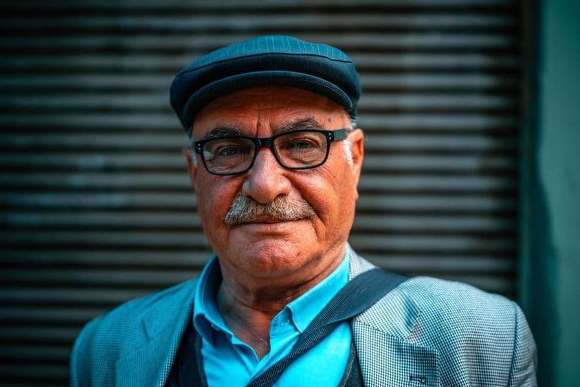 Homme âgé portant un chapeau dans la rue.