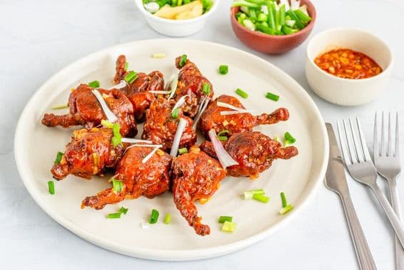 Chicken lollipop, un amuse-bouche au poulet populaire garnie d'échalotes.