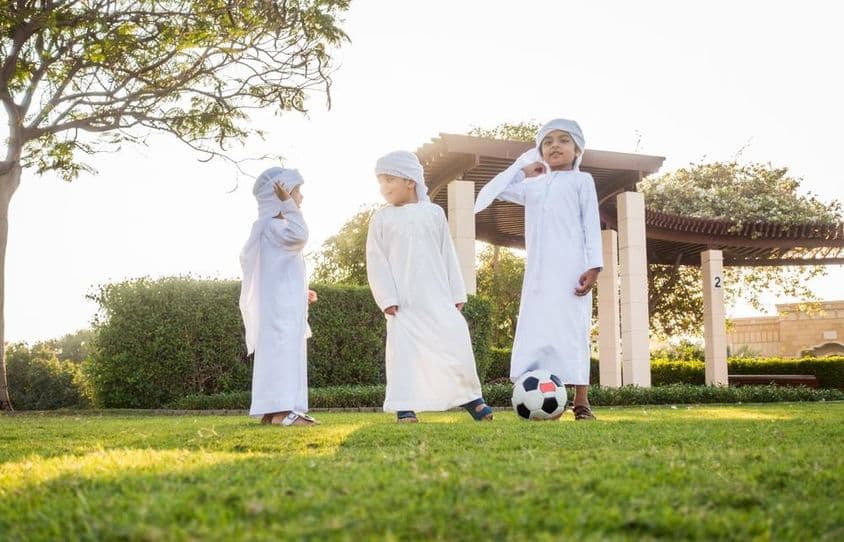 Un groupe d'enfants du Moyen-Orient jouant et s'amusant en plein air.
