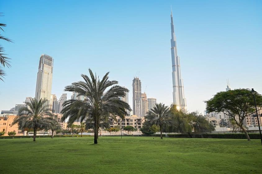 Dubaï, Émirats Arabes Unis, parc vert dans une zone résidentielle avec Burj Khalifa en arrière-plan.