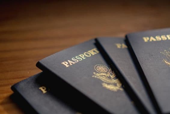 Passeports empilés sur une table en bois.