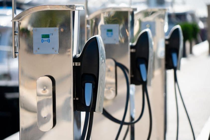 Station de recharge pour voiture électrique à une marina de luxe au bord de la mer.