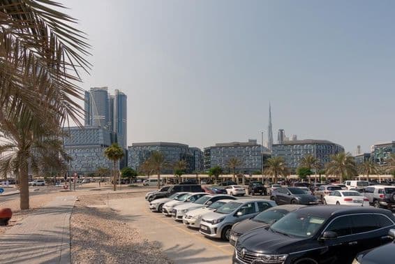 Voitures garées à Dubaï avec le Burj Khalifa en arrière-plan.