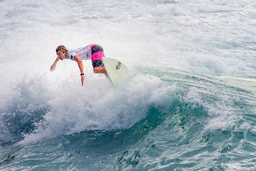 Jeune garçon surfant une grosse vague.