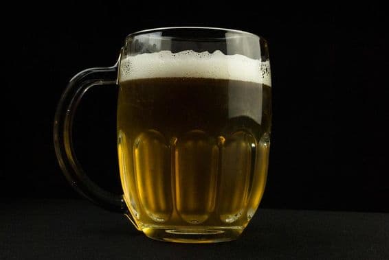 Chope de bière avec une mousse sur le dessus.