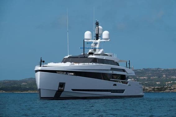 Un grand yacht blanc ancré dans une eau bleue.