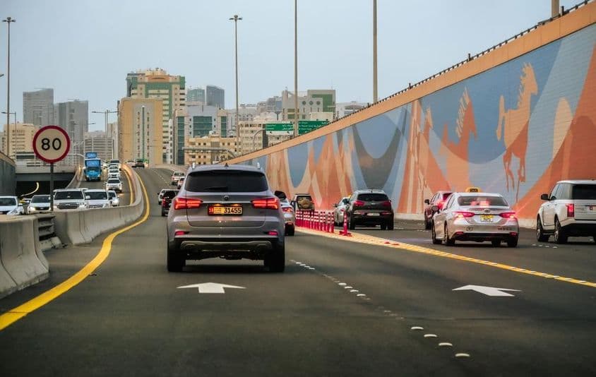Trafic automobile sur une autoroute avec des gratte-ciels en arrière-plan à Dubaï, Émirats Arabes Unis.