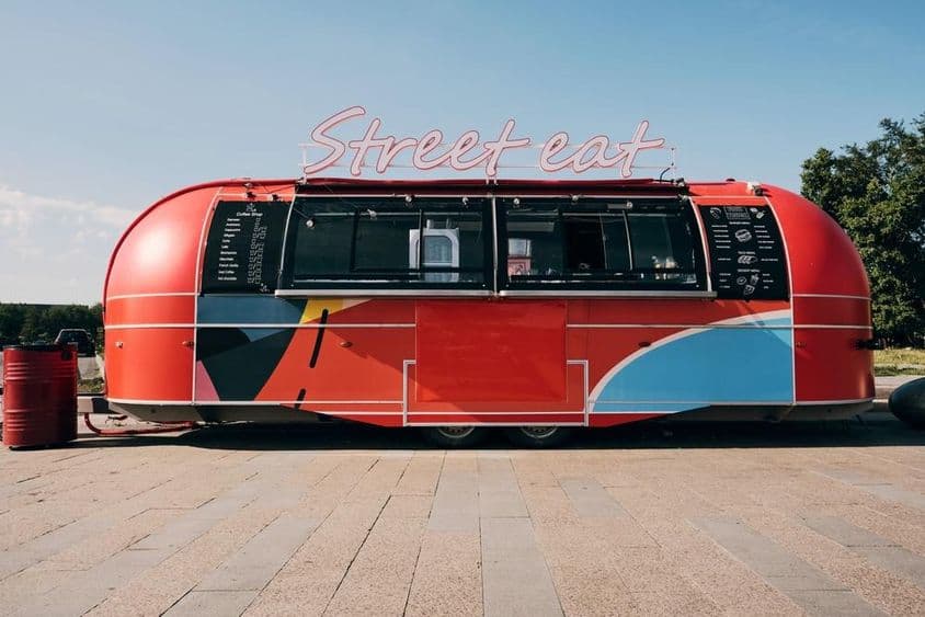Camion de nourriture rouge, vente de restauration rapide au milieu de la rue ou de la place.