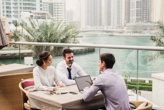 Réunion d'affaires sur un balcon moderne à Dubai Marina.