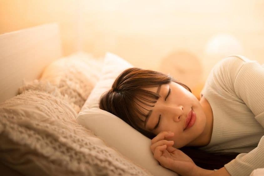 Une femme dormant dans un lit.