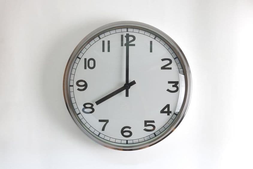 Horloge murale ronde en acier inoxydable avec cadran blanc.