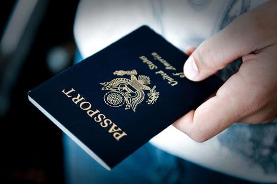 Homme tenant un passeport bleu.