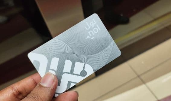 Voyageur à Dubaï tenant un pass d'entrée avec carte Nol de métro.