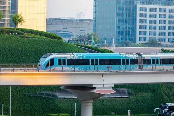 Train de métro sans conducteur se déplaçant dans Dubaï sous un jour ensoleillé.