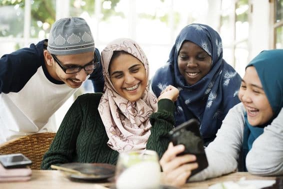 Groupe d'étudiants regardant une leçon sur un téléphone mobile.