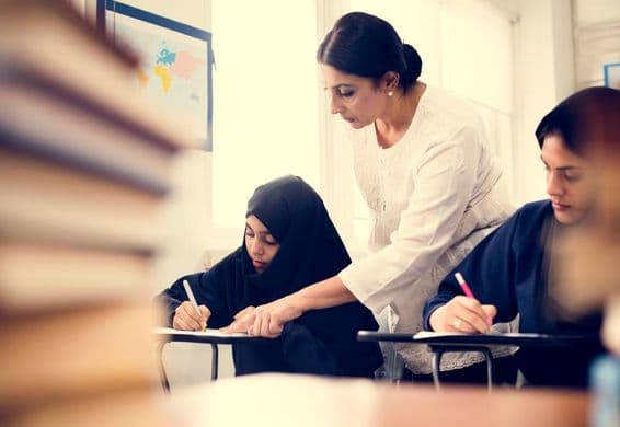 Filles musulmanes étudiant dans une salle de classe.