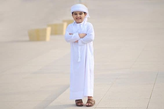 Jeune étudiant arabe souriant en route pour l'école.