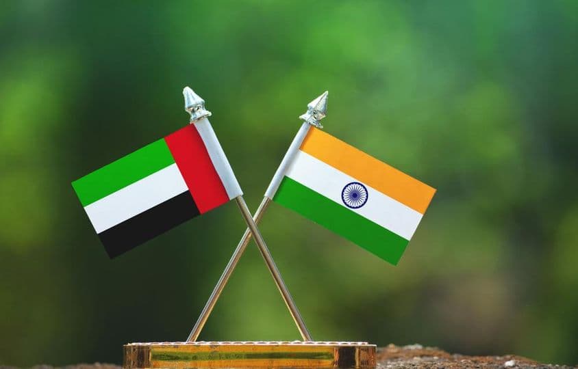 Petits drapeaux de l'Inde et des ÉAU contre un arrière-plan vert flou.